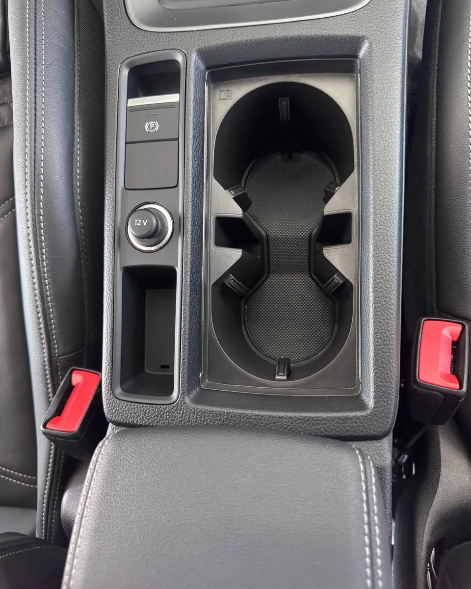 The same centre console after a TNT interior detail in Miami — cup holders cleaned out and plastics dressed